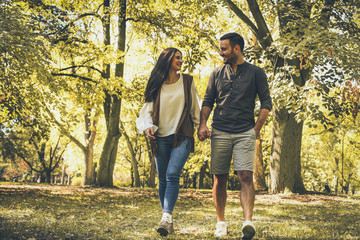 Happy couple outdoor walking trough woodland.