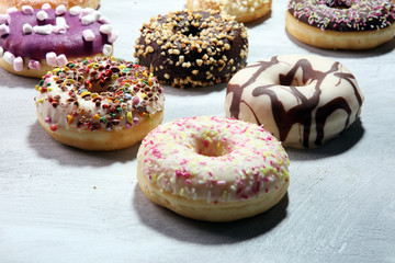 assorted donuts with chocolate frosted, pink glazed and sprinkles donuts