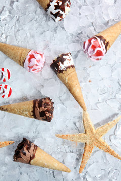 ice cream in waffle cone and strawberry, raspberry and chocolate softice cream.