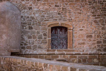 An old, covered wooden door against the backdrop of a stone peeling wall. Moroccan style. Africa, Morocco, Essaouira