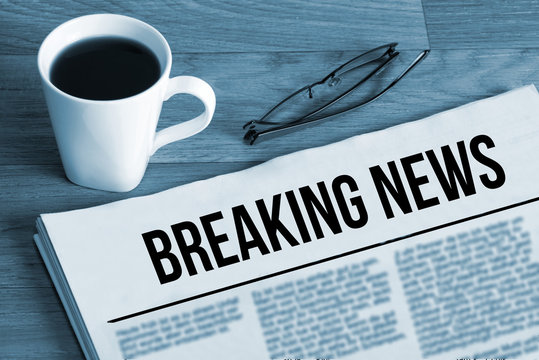 Eine Tasse Kaffee, Brille und Zeitung mit dem Titel Breaking News