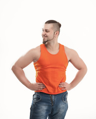 portrait of a sporty guy - bodybuilder in jeans and orange t-shi