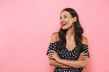 Asian woman posing over pink background looking aside.