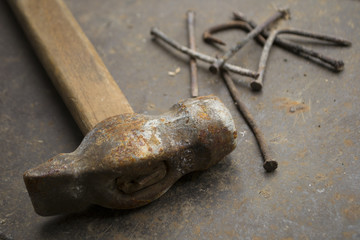 rusty hammer with nails on metal
