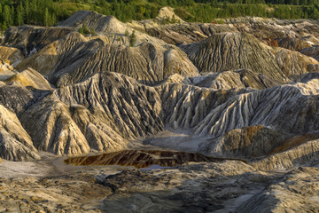 landscape - a fragment of a quarry of kaolin mining with beautiful slopes with traces of streams