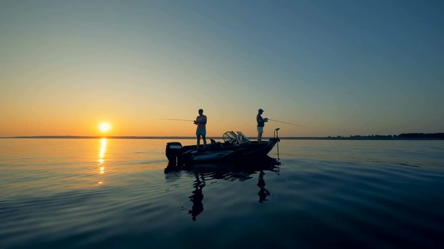 Sunrise waterscape of several men fishing