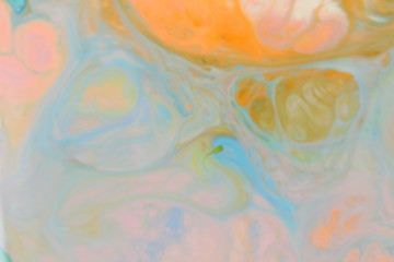Fluid art. Abstract orange green background on liquid. Multicolored stains of paints. Blurred pattern for designer. Contemporary Art
