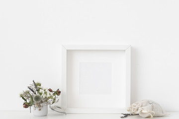 White square portrait frame mockup with small bouquet of dried flowers in pot and sachet with...