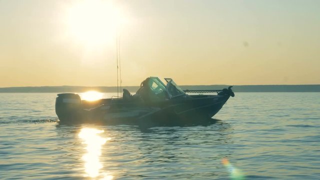 Male anglers are slowly sailing on a speedboat