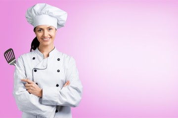 Portrait of young woman chef on background