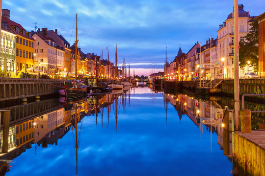Panorama of Nyhavn with colorful facades of old houses and old ships in the Old Town of Copenhagen, capital of Denmark.
