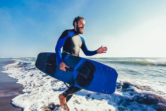 Portrait of surfer man with surf board on the beach. Summer sport activity
