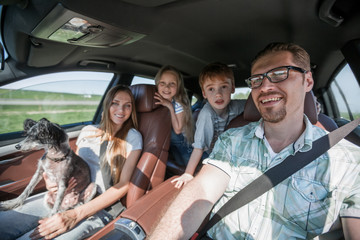 friendly family travels in a comfortable car - obrazy, fototapety, plakaty