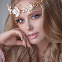 Delicate portrait of a young model girl. The image of the bride, a light lace dress in pink, a beautiful hairstyle and a natural make-up. Light photo studio, natural light from the window.