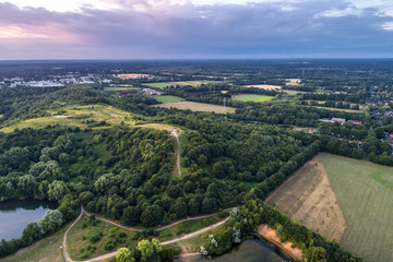 Fototapeta na wymiar Aerial view of amazing sunset over the park in Germany. Hill and lake from birds eye view. 