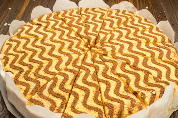 Dark chocolate vegan cake with candies and nuts on wooden background