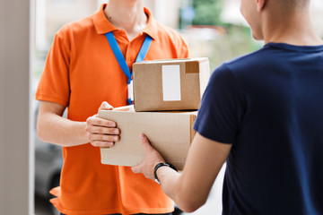 A person wearing an orange T-shirt and a name tag is delivering parcels to a client. Friendly worker, high quality delivery service. - obrazy, fototapety, plakaty