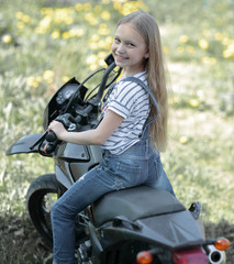 Fototapeta na wymiar little biker girl riding her motorcycle