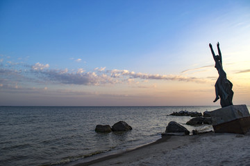 The Galatea Statue on the sunset beach Sea of Azov. Beautiful sunset on deserted beach Azov Sea.