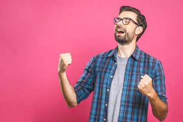 Yeah! Happy winner! Happy young handsome man gesturing and keeping mouth open while standing...