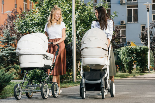 mothers walking with baby strollers on street
