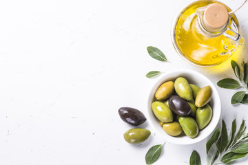 Olives and olive oil on white.