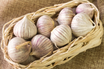 Wicker basket with garlic on linen fabric.