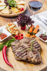 Modern style barbecue dry aged sliced roast beef with fried onion rings and mashed potatoes as closeup on a plate