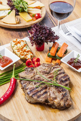 Modern style barbecue dry aged sliced roast beef with fried onion rings and mashed potatoes as closeup on a plate