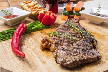 Modern style barbecue dry aged sliced roast beef with fried onion rings and mashed potatoes as closeup on a plate