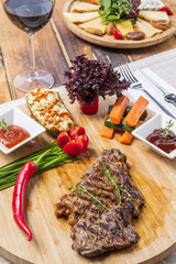 Modern style barbecue dry aged sliced roast beef with fried onion rings and mashed potatoes as closeup on a plate