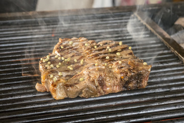 Beef steaks on the grill with flames