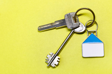keys with a house on a yellow background