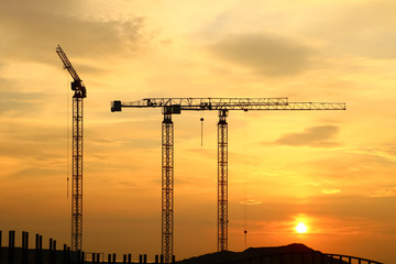 silhouette of construction and cranes in the evening on the sunset