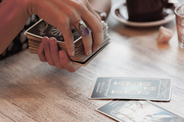 Woman is reading Tarot cards in cafe