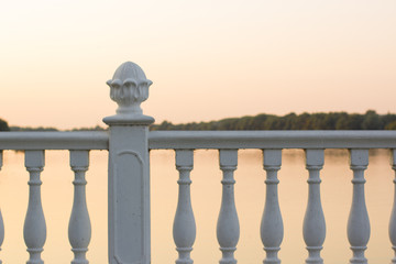 white classic fence frame in evening sunset time on river shore waterfront district for walking with soft colors and empty copy space for your text