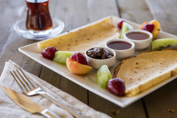 Healthy summer breakfast,homemade classic american pancakes with fresh berry and honey, morning light grey stone background copy space top view