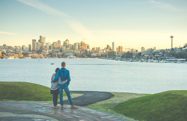 Fototapeta na wymiar a couple hug and looking Seattle city landscape with sunset ,Seattle,Washington,USA.