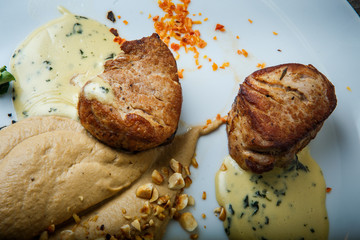 macro of two tasty pieces of grilled meat with puree and sauce