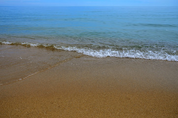 Wet sand on the beach. A part of the sea is visible.