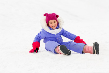 Fototapeta na wymiar childhood, leisure and season concept - happy little girl in winter clothes outdoors