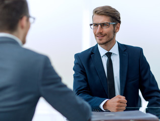 business partners talk sitting at a Desk