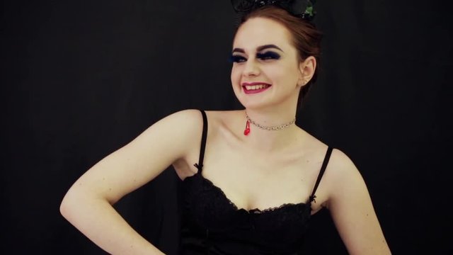 a girl in a corset and with horns on her head is smilling