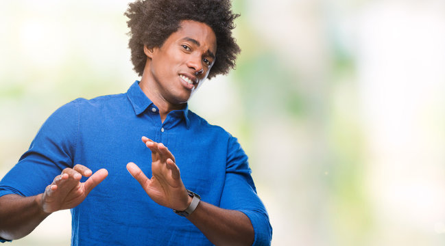 Afro american man over isolated background disgusted expression, displeased and fearful doing disgust face because aversion reaction. With hands raised. Annoying concept.