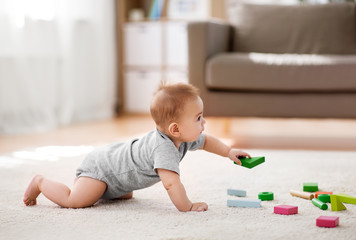 babyhood, childhood and people concept - little asian baby boy playing with toy blocks at home