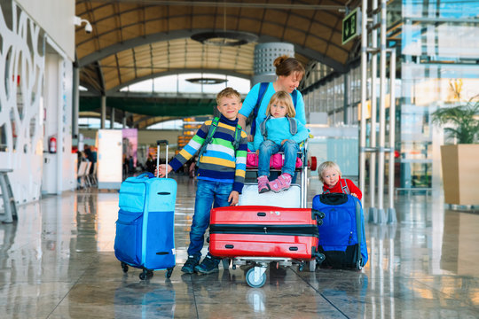 family travel -mother with kids and suitcases in airport