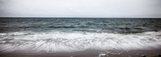 artistic moving blurred background of the foam of the waves that wash up on the beach