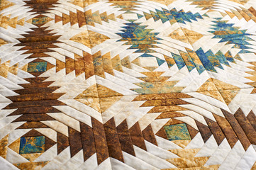 Fragment of quilt stitched from pineapple pattern blocks