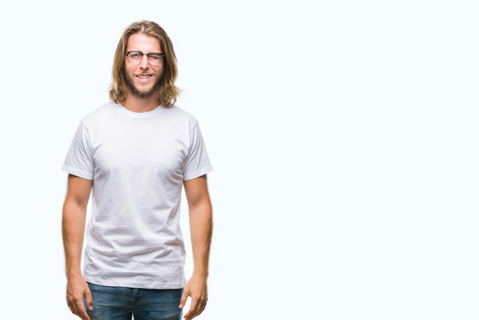 Young handsome man with long hair wearing glasses over isolated background winking looking at the camera with sexy expression, cheerful and happy face.