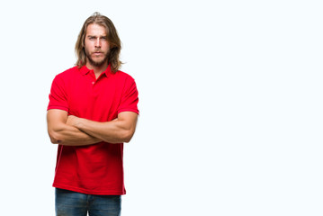 Young handsome man with long hair over isolated background skeptic and nervous, disapproving...